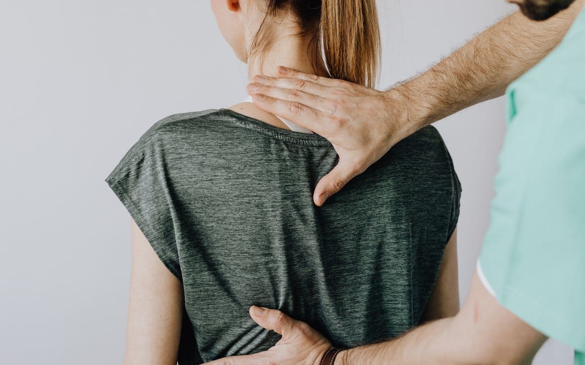 Clinician examining a patient's lower back
